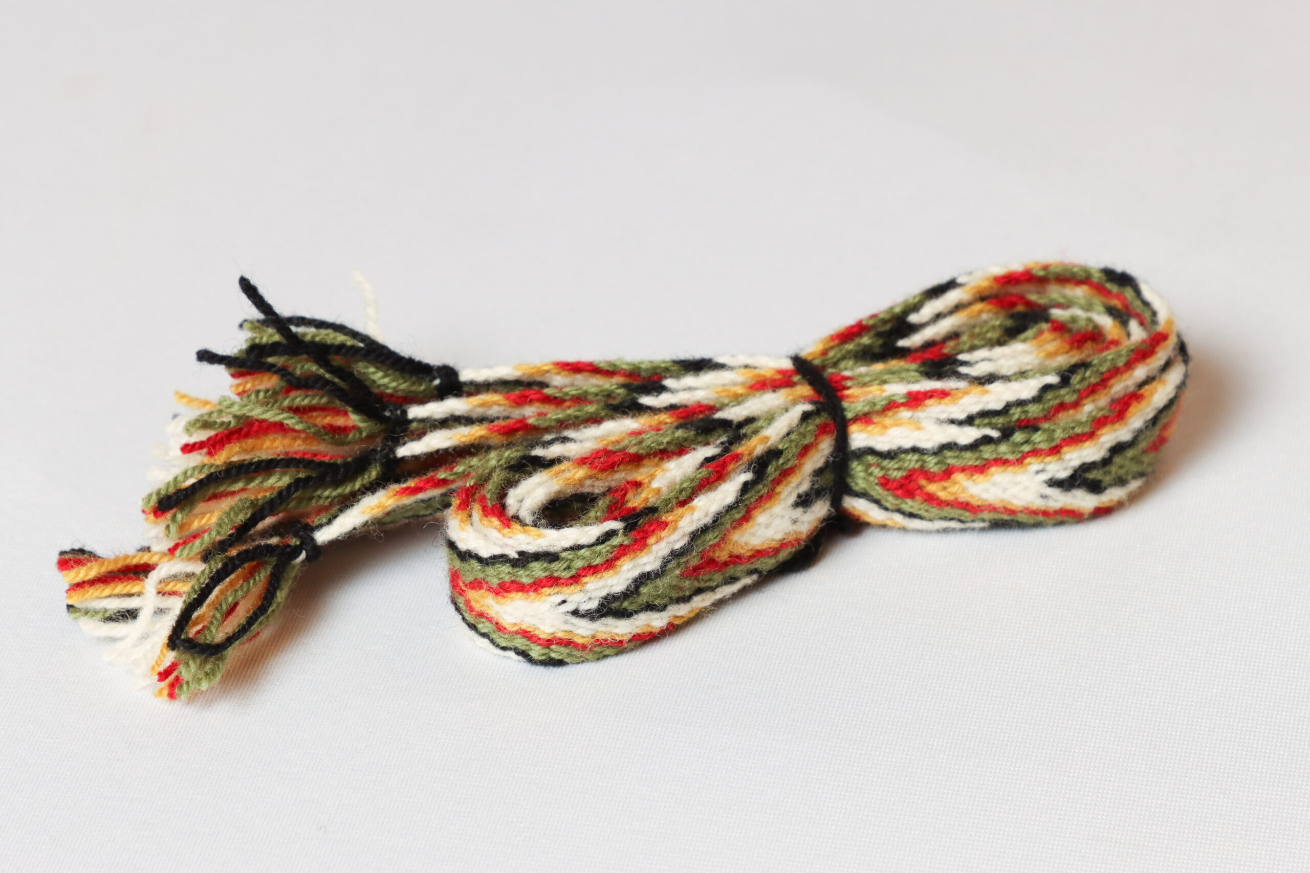 Sokkebånd til bunad fra Rogaland i fargene rødt, grønt, gult, svart og hvitt.